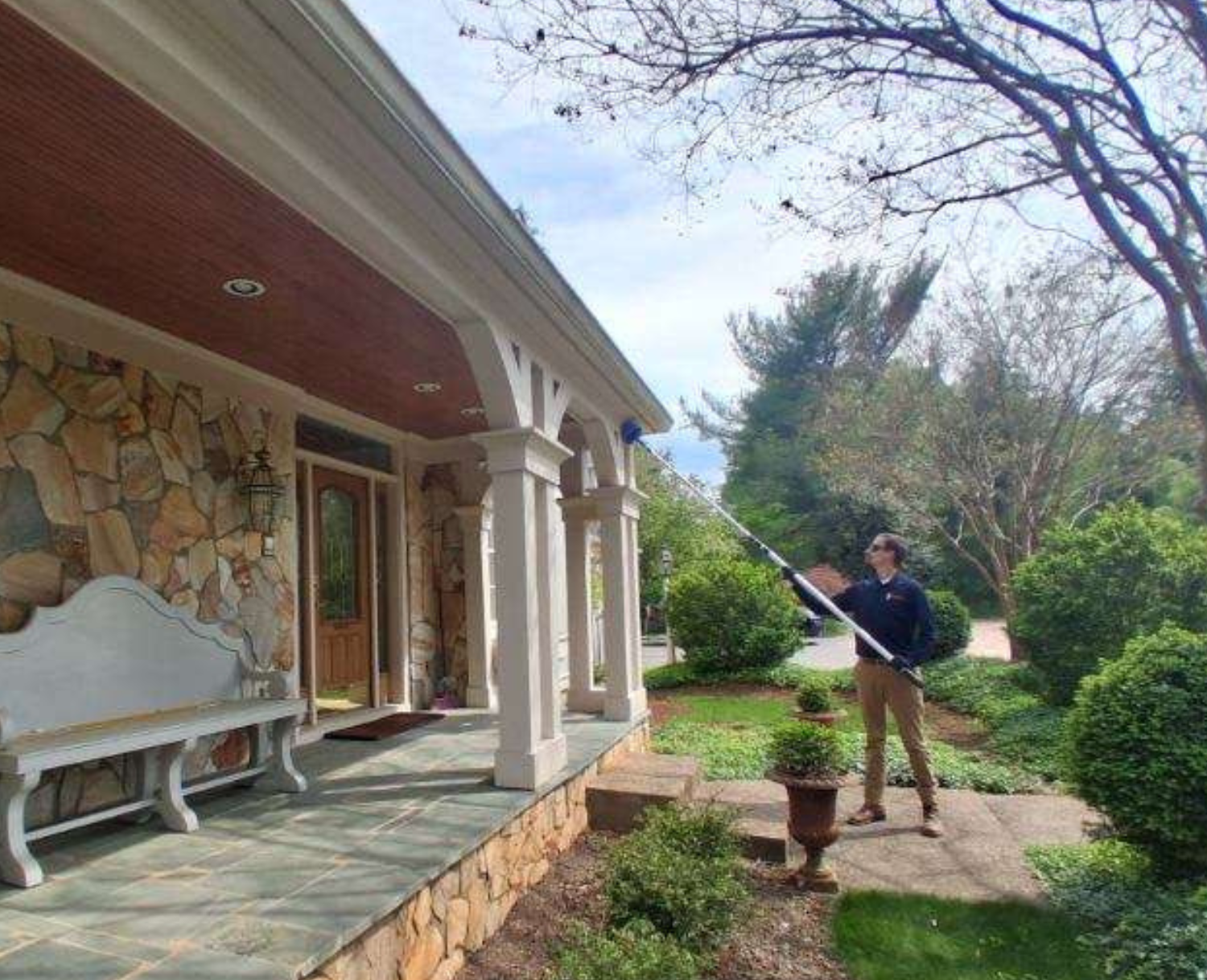 A man works in the garden, spraying weeds from a sprayer.<br />